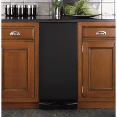 a black dishwasher sitting on top of a wooden cabinet next to a counter