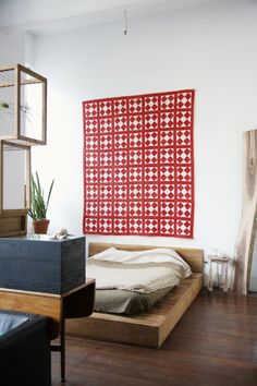 a bed sitting on top of a hard wood floor next to a wall mounted screen