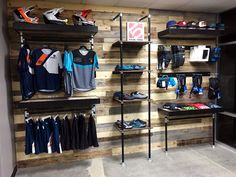 the inside of a sports shop with wooden walls and shelves filled with shoes, t - shirts, and other items