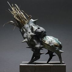 a sculpture of a fish with grass in its mouth