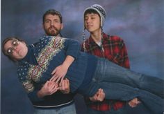 three people are posing for a photo with one person upside down on the other's head