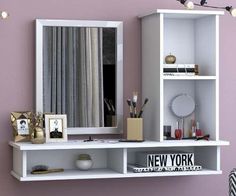 a white shelf with a mirror and other items on it in front of a purple wall