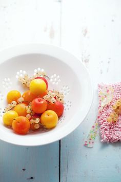 a white bowl filled with fruit on top of a table