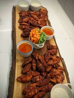 chicken wings and dipping sauces on a cutting board