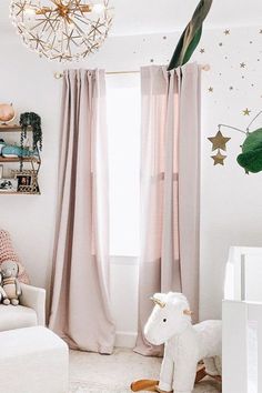 a baby's room with a rocking horse in the corner and stars on the ceiling