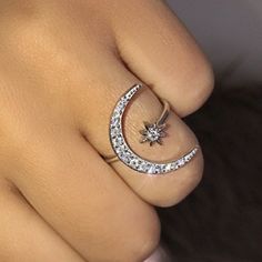 a close up of a person wearing a ring with a star and moon on it