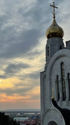 an image of a church with a cross on it's steeple at sunset