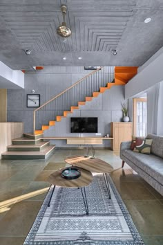 a living room with couches, coffee table and stair case in the center area