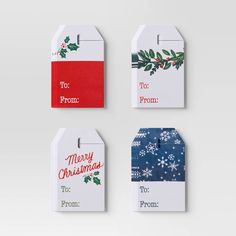 four christmas gift tags hanging on a wall