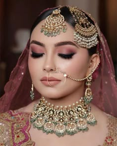 a woman wearing a bridal outfit and jewelry