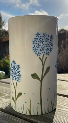 a white coffee cup with blue flowers painted on it