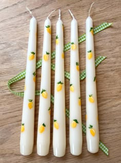 four white candles with lemons on them