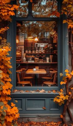 an outdoor cafe with autumn leaves covering the windows