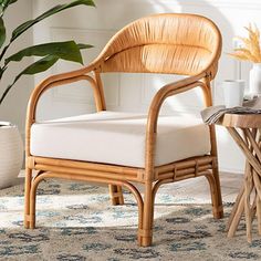 a wicker chair sitting on top of a rug next to a potted plant