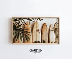 four surfboards are lined up in a wooden box with the words garden on it