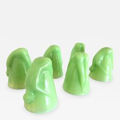 four green plastic figures sitting next to each other