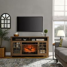 a living room with a couch, fireplace and television on the wall in front of it