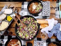 a table topped with lots of food and plates filled with different types of foods on top of it