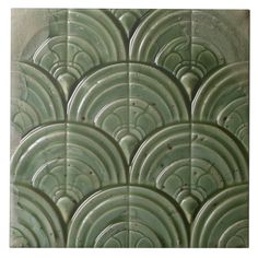 a close up view of an art deco tile pattern in green and grey tones with circles