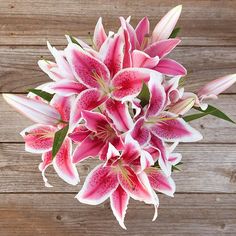 a bouquet of pink flowers sitting on top of a wooden table