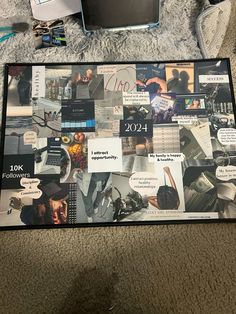 a laptop computer sitting on top of a rug covered in papers and pictures with words all over it