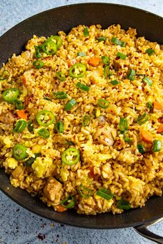 a pan filled with rice and vegetables on top of a table