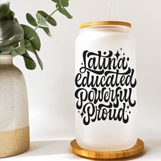 a white can with the words latin is next to a potted plant on a table