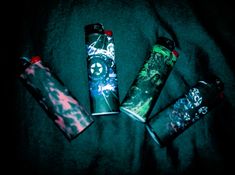 three lighters sitting next to each other on a bed