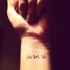 a woman's wrist tattoo with the word no nii on it, in cursive writing