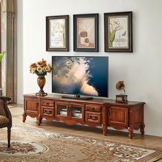 a large flat screen tv sitting on top of a wooden entertainment center in a living room