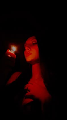 a woman holding a lit candle in the dark