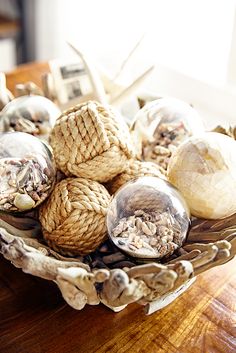 a bowl filled with seashells on top of a wooden table