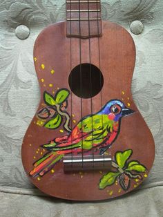 a ukulele with a colorful bird painted on it