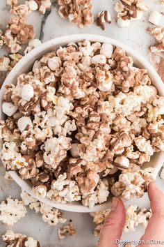 a bowl filled with chocolate popcorn on top of a table