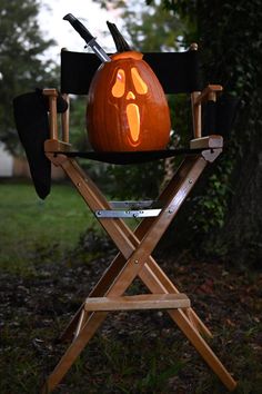 a wooden chair with a carved pumpkin on it's back and two knives sticking out of the top