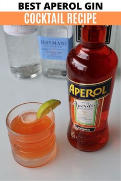 a bottle of alcohol next to a glass with a lime on it and the words best aperol gin cocktail recipe