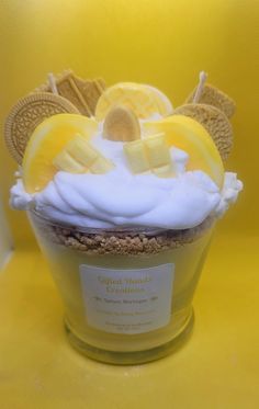 a cupcake topped with whipped cream, lemon slices and graham crackers on a yellow background