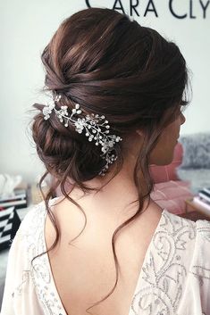 the back of a woman's head wearing a hair comb with flowers on it