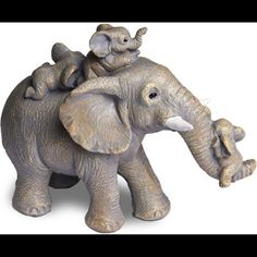 an elephant figurine with two baby elephants on its back