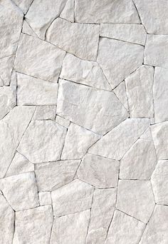 a white stone wall with cracks in it