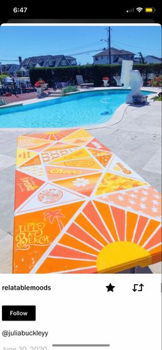 an orange and yellow picnic table next to a swimming pool