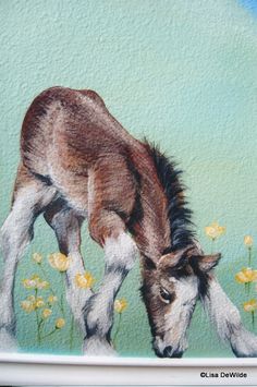 a painting of a baby horse grazing on flowers