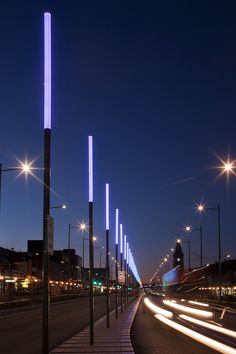 an empty city street at night with light streaks on the road and buildings in the background