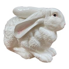 a white ceramic rabbit figurine on a white background