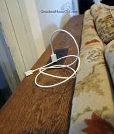 an electronic device is plugged into a cord on top of a couch in the living room