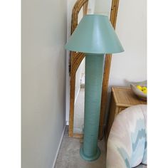 a blue lamp sitting next to a mirror in a room with a chair and table