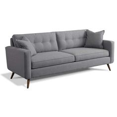 a gray couch with two pillows on it's back and one arm folded down