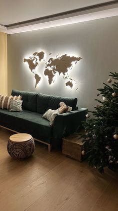 a living room decorated for christmas with a green couch and world map on the wall