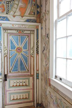 the door is painted with colorful designs on it's sides and has a window above it