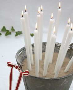 there are many candles that are in the bucket with some candy canes on it